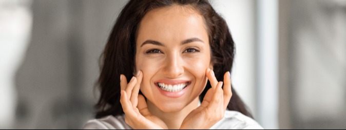 Woman touching her cheeks and smiling